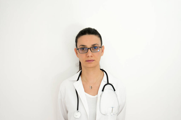 Portret van een arts in verschillende hoeken en lichten voor een witte muur. Selectief focusgezicht. - Foto, afbeelding