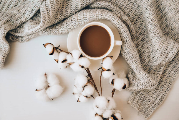 Чашка кави з паличками кориці та зіркою анісу на білому тлі. светр навколо. Зимовий ранок. Перерва на каву. Копіювати простір. Вид зверху. Сніданок. Плоский прошарок
 - Фото, зображення