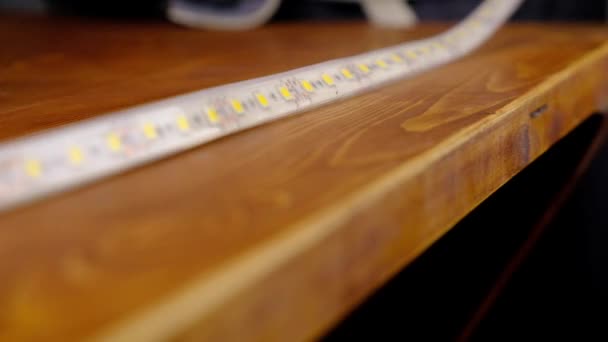 montáž LED světla na pracovní plochu, mistr zkouší na LED pásku - Záběry, video