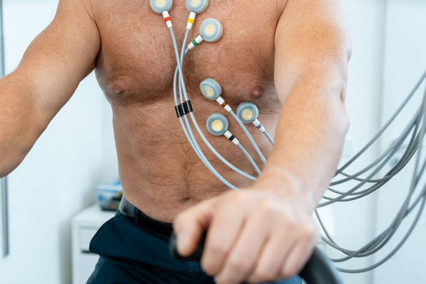 Patient sur vélo d'appartement avec électrodes pendant ECG - Photo, image
