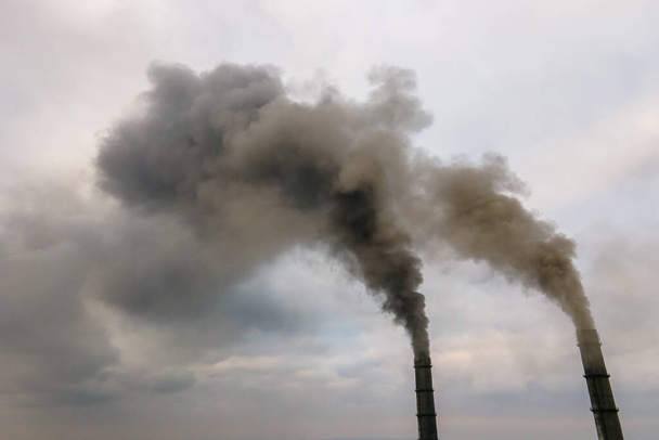Vista aérea de las altas tuberías de las centrales eléctricas de carbón con humo negro subiendo por la atmósfera contaminante. - Foto, imagen