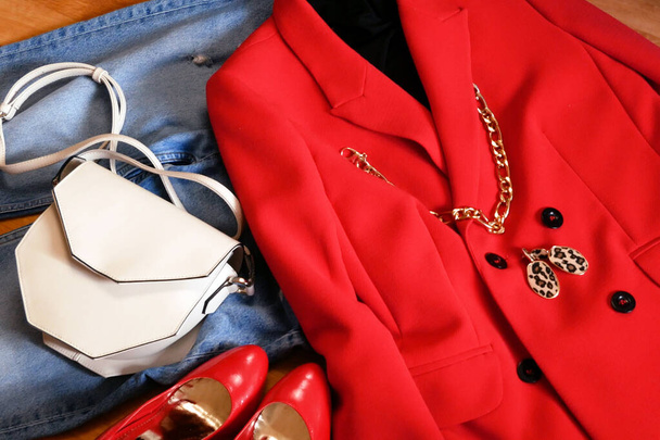 moderno atuendo de lana con chaqueta roja y jeans y bolsa geomética blanca, primer plano - Foto, Imagen