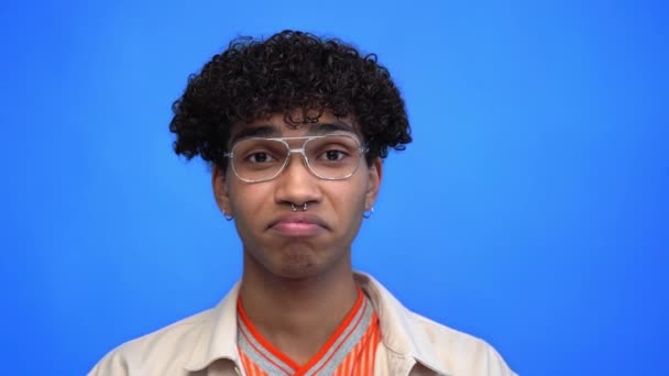 joven y perforado afroamericano hombre asintiendo aislado en azul - Metraje, vídeo