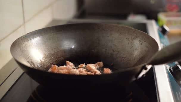 Pieces of chicken fillet fried in a pan. Golden crust on meat. Boiling oil. Cook at home. Looks appetizing. A quick and unhealthy dinner. Mint fibers. The wooden spatula is stirring. Heat. - Footage, Video
