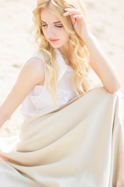 Portrait of a beautiful young blonde woman with wavy hair in nature - Φωτογραφία, εικόνα