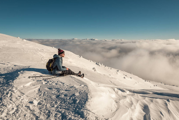 hiker sitting and resting on the snow in winter mountains - Foto, Bild