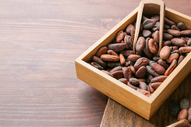Коробка с бобами какао на деревянном фоне - Фото, изображение