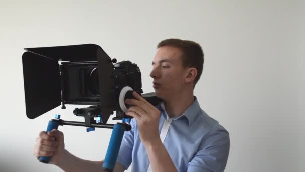 Mann filmt mit professioneller Kamera und Lächeln - Filmmaterial, Video