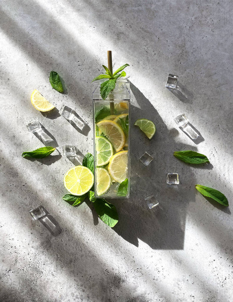Agua infundida de lima fresca, limón y menta, cóctel, bebida desintoxicante, limonada en botella reutilizable - Foto, Imagen