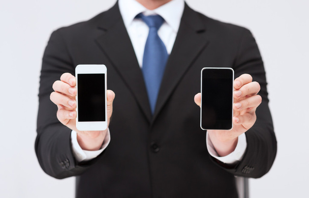 Businessman showing smartphones with blank screens - Zdjęcie, obraz