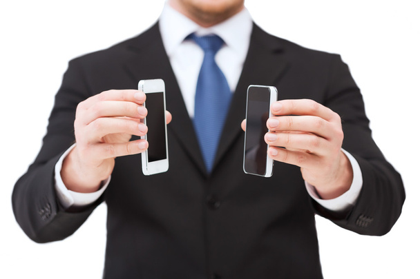 Liikemies osoittaa älypuhelimet tyhjät näytöt
 - Valokuva, kuva