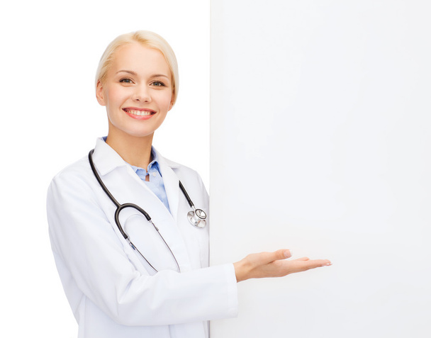 Smiling female doctor with white blank board - Foto, Imagen