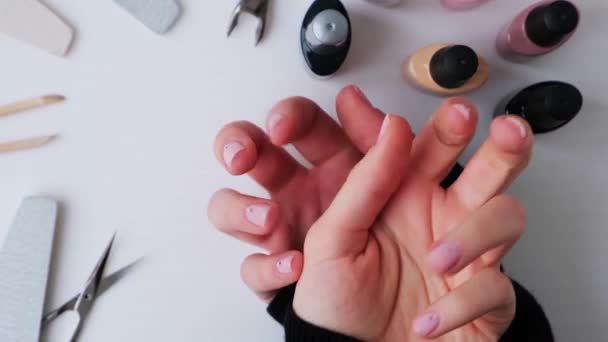 マニキュアを示す女性の手。爪、美容室、爪で自宅で仕事のための広告。ネイルケア、セルフケア。女性のマニキュア。自分でマニキュアをする - 映像、動画