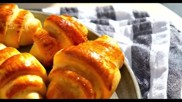 Homemade delicious croissants on a dessert gray plate on kitchen towel rotating. Tasty homemade croissants cake - Footage, Video