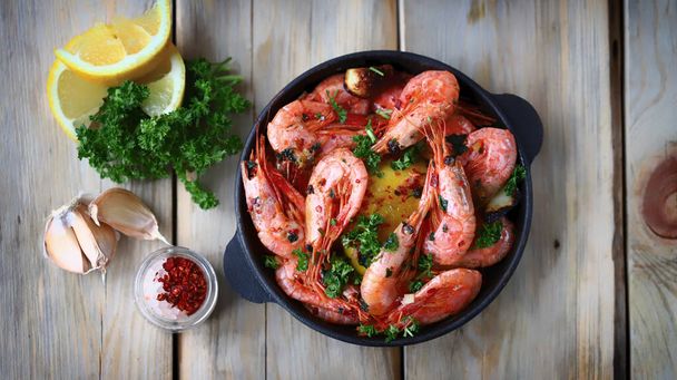 Shrimp in a frying pan. Fried flamb shrimps in shells with spices. - Photo, Image