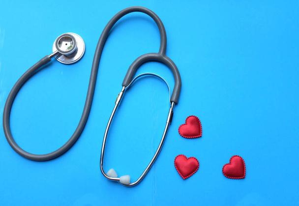  стетоскоп і серце з червоної тканини на синьому фоні. Концепція охорони здоров'я
 - Фото, зображення