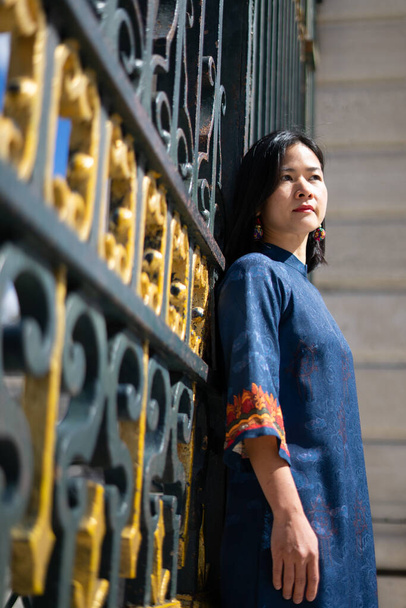 giovane asiatica modello di donna in posa con abito tradizionale con un recinto imperiale sullo sfondo - Foto, immagini