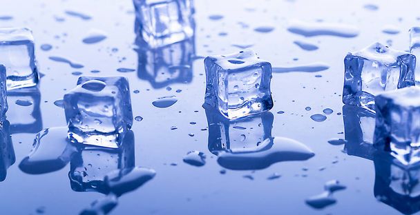 brokken bevroren ijs op een glanzend oppervlak met druppels helder water van dichtbij - Foto, afbeelding