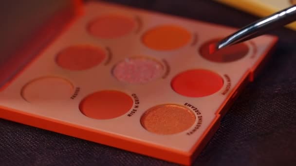 Nahaufnahme des kosmetischen Pinsels in der Nähe der Palette mit buntem Lidschatten  - Filmmaterial, Video
