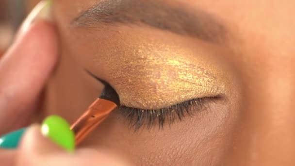 částečný pohled na africkou americkou ženu aplikující oční vložku s kosmetickým štětcem - Záběry, video