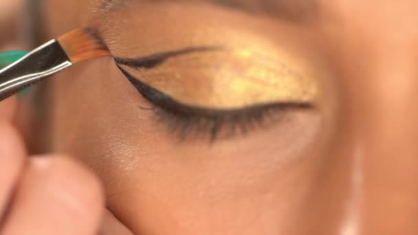 vista recortada de mujer afroamericana aplicando delineador de ojos negro - Metraje, vídeo