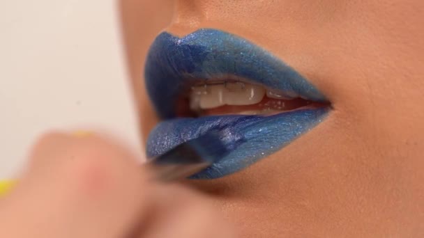 partial view of woman applying blue lipstick with cosmetic brush - Video