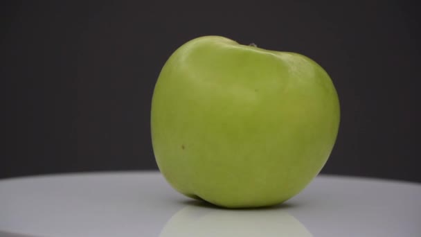 grüne und frische Apfelspinnerei auf weißer Oberfläche isoliert auf schwarzer - Filmmaterial, Video