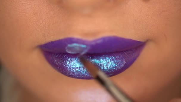 vista recortada de la mujer que aplica brillo labial con brillo en los labios púrpura  - Imágenes, Vídeo