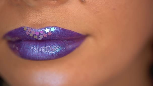gedeeltelijk uitzicht van de vrouw glanzende sterren op paarse lippen - Video