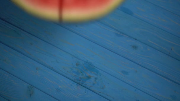 ylhäältä näkymä kypsä vesimeloni putoaa siniselle pinnalle - Materiaali, video