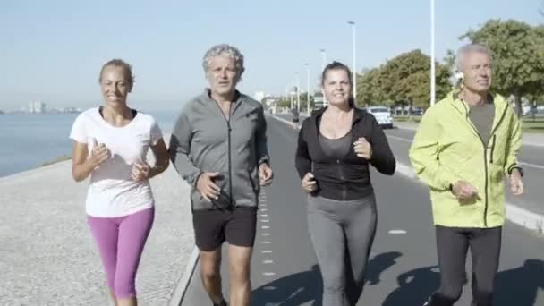 Feliz amigos ativos correndo na estrada perto do mar - Filmagem, Vídeo