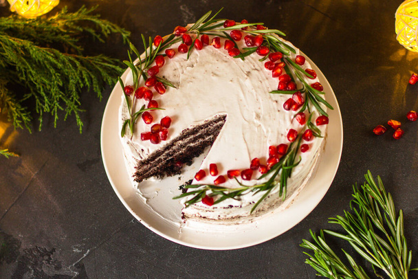 chocolate cake with cream decorated with pomegranate seeds - Fotó, kép