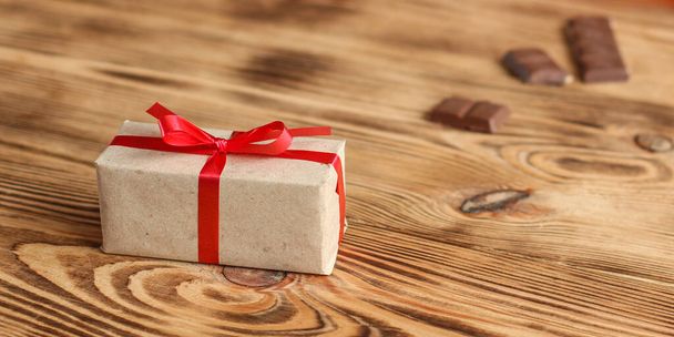 caja de regalo con cinta roja sobre fondo de madera - Foto, Imagen