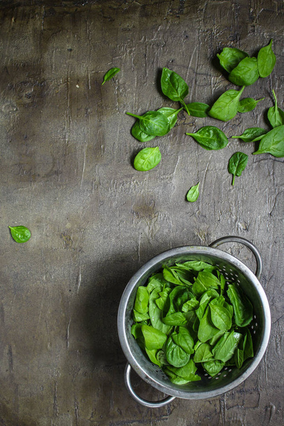 top view of fresh green spinach leaves on a gray background - Foto, afbeelding