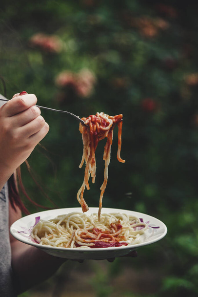 mujer comiendo espaguetis con salsa roja - Foto, Imagen