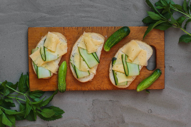 sendviče s okurkou a sýrem na šedém pozadí. close-up - Fotografie, Obrázek