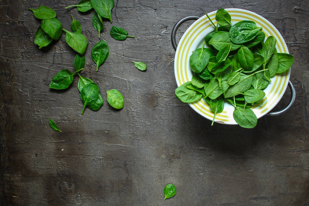 top view of fresh green spinach leaves on a gray background - 写真・画像