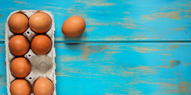 eggs in a box on a blue wooden background. top view. free space for text.  - Photo, Image