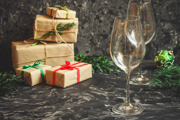 Рождественский фон с подарочными коробками и стаканами на темном столе. - Фото, изображение