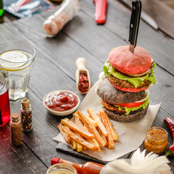 closeup shot of a delicious burgers with vegetables and cheese on table - Photo, Image