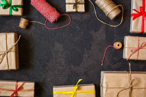 верхний вид рождественских подарочных коробок и нитей на черном фоне - Фото, изображение
