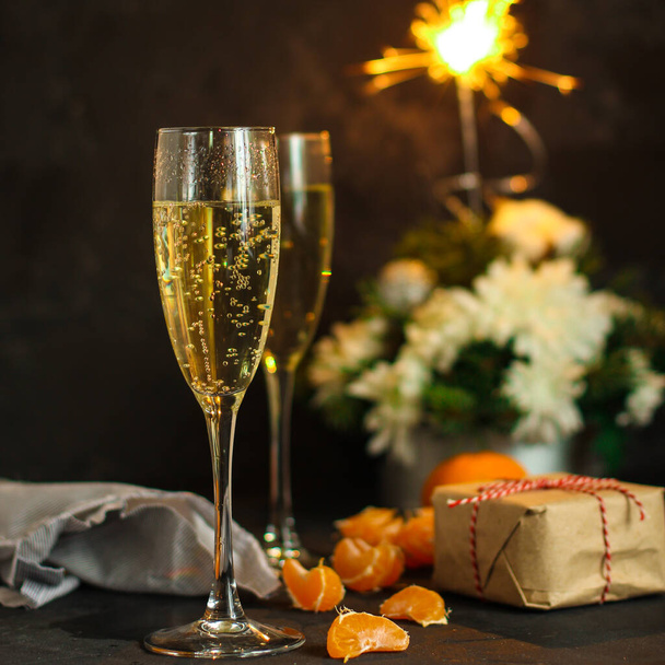 різдвяний фон з келихами шампанського та подарунковою коробкою на столі
 - Фото, зображення
