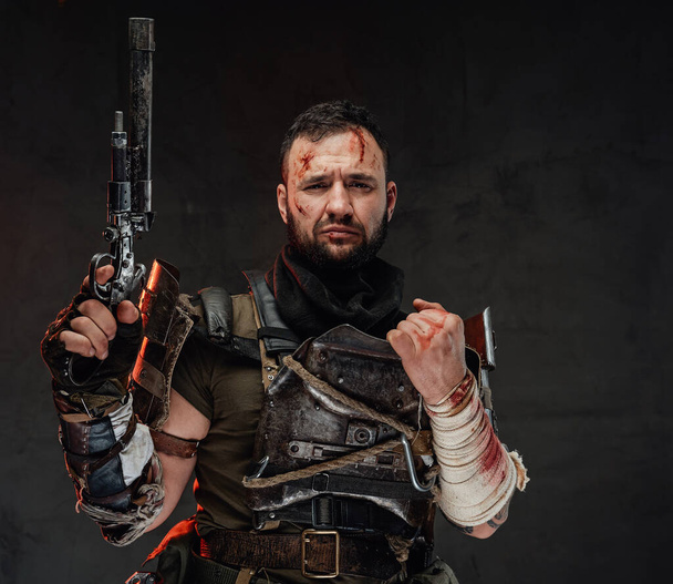 Выживший бородатый после апокалипсиса позирует с пистолетом - Фото, изображение