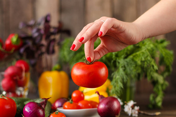 woman hands holding fresh vegetables on wooden table - Фото, зображення