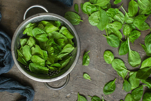 top view of fresh green spinach leaves on a gray background - Fotografie, Obrázek