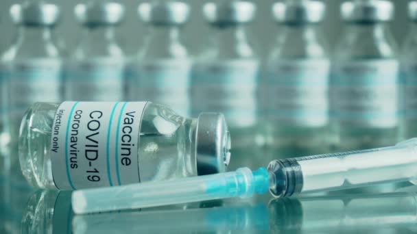 Tıbbi hizmet merkezindeki ayna masasına enjeksiyon için anti koronavirüs aşısı ve şırınga içeren şişe veya şişeler buhar tedavisi görmektedir. - Video, Çekim