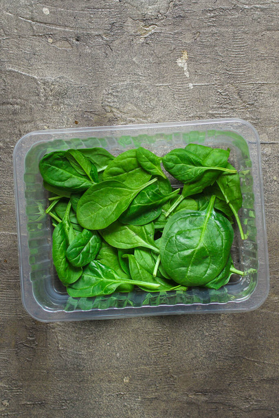 top view of fresh green spinach leaves on a gray background - Photo, Image