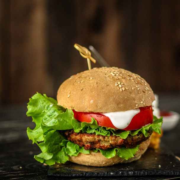 detailní záběr lahodné hamburgery se zeleninou a sýrem na stole - Fotografie, Obrázek