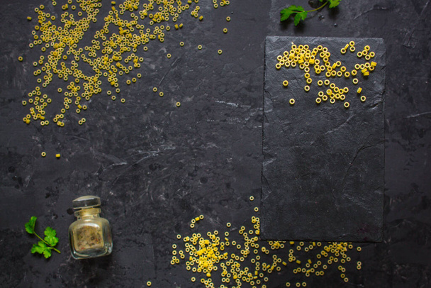 pohled shora, kulaté nevařené těstoviny na černém pozadí - Fotografie, Obrázek