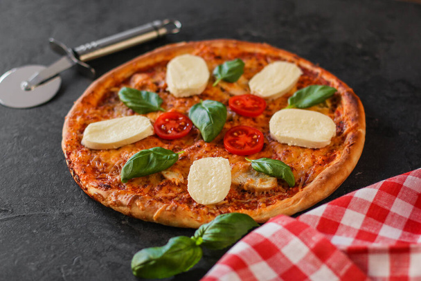 pizza with mozzarella, basil and vegetables on a black background. close-up view. copy space - Photo, image